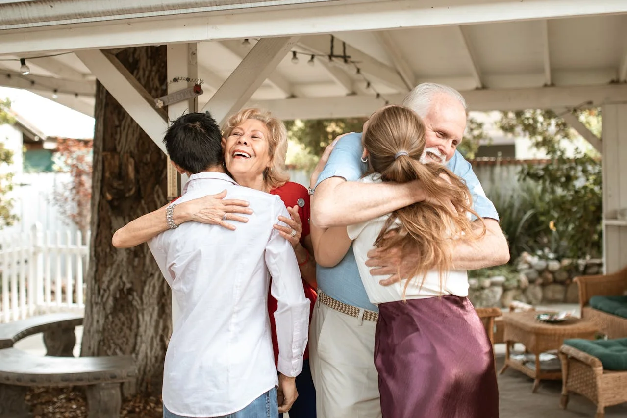 Adultos mayores hispanos abrazando a sus nietos con alegría y bienestar, gracias a la cobertura de Medicare en California